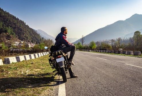 biker sitting with his motorcycle on the side of the road