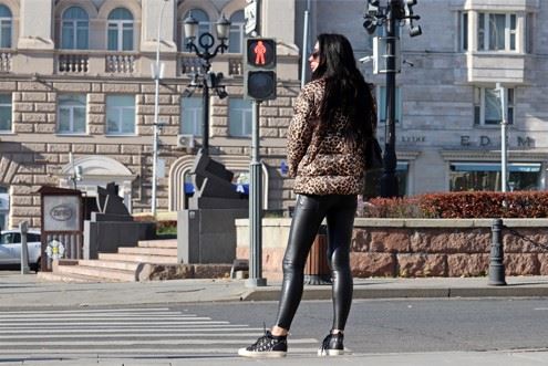 woman waiting to cross the street at a crosswalk