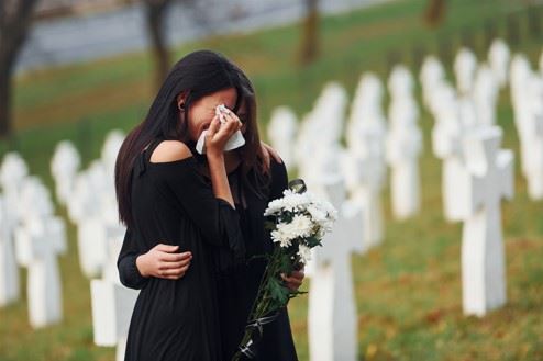 young women crying at funeral